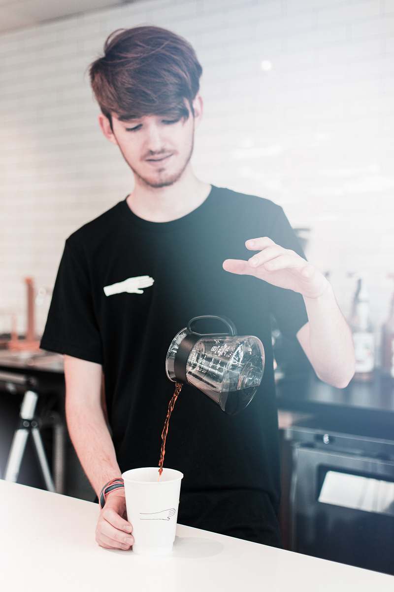 person man pouring liquid on white cup people