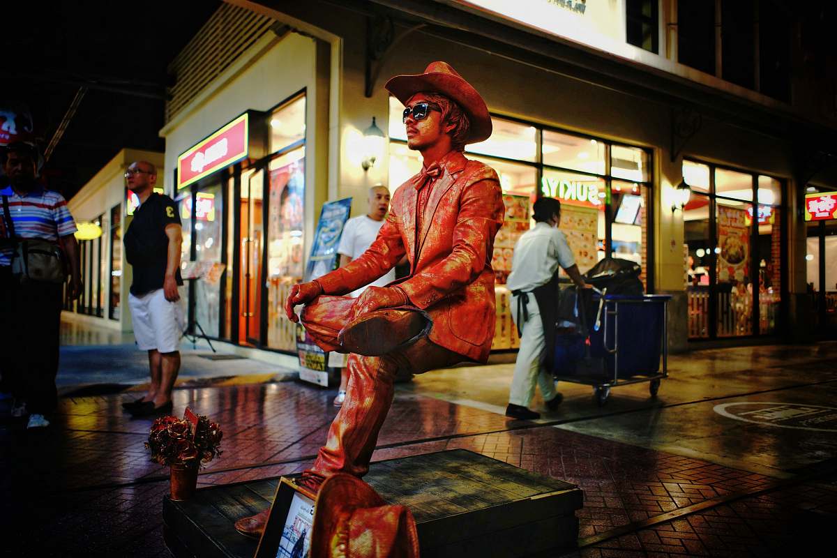people man wearing sunglasses statue near store person