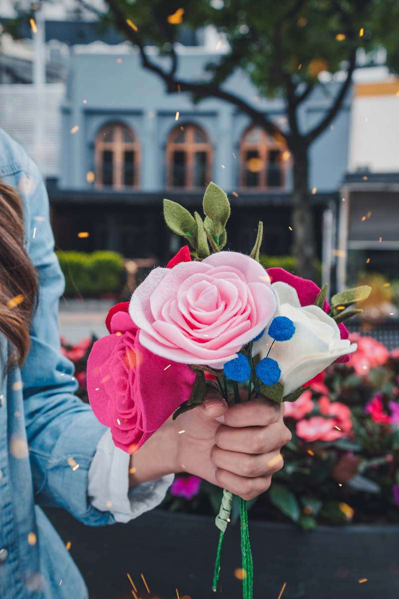 person woman holding pink and white petaled faux flower people