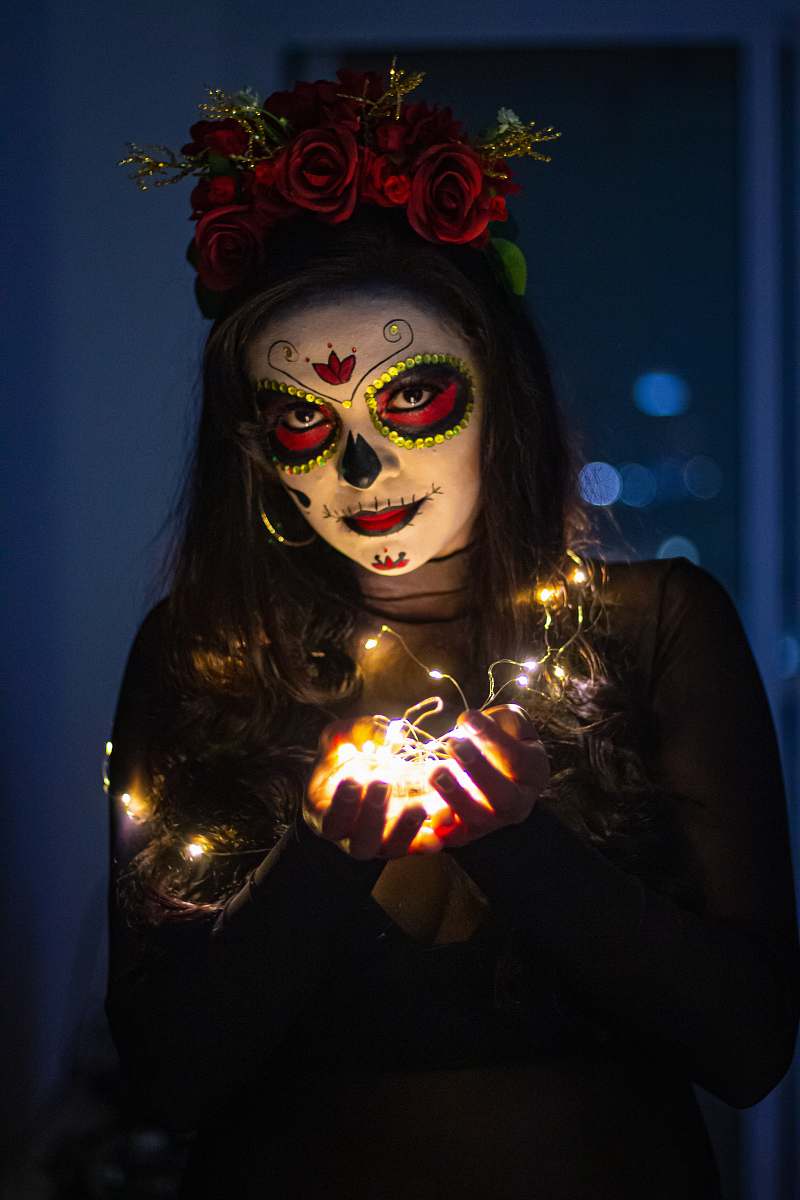 person woman with sugar skull paint face mask light