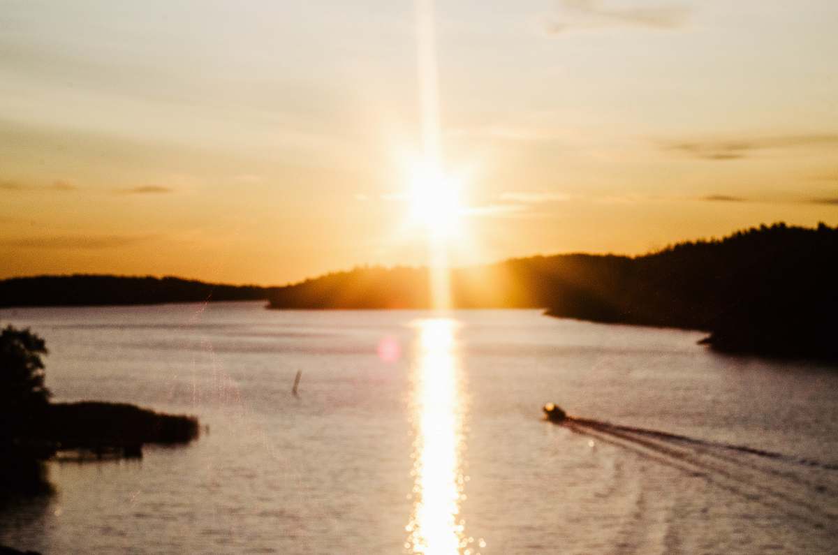 finland boat running on sea during golden hour sun