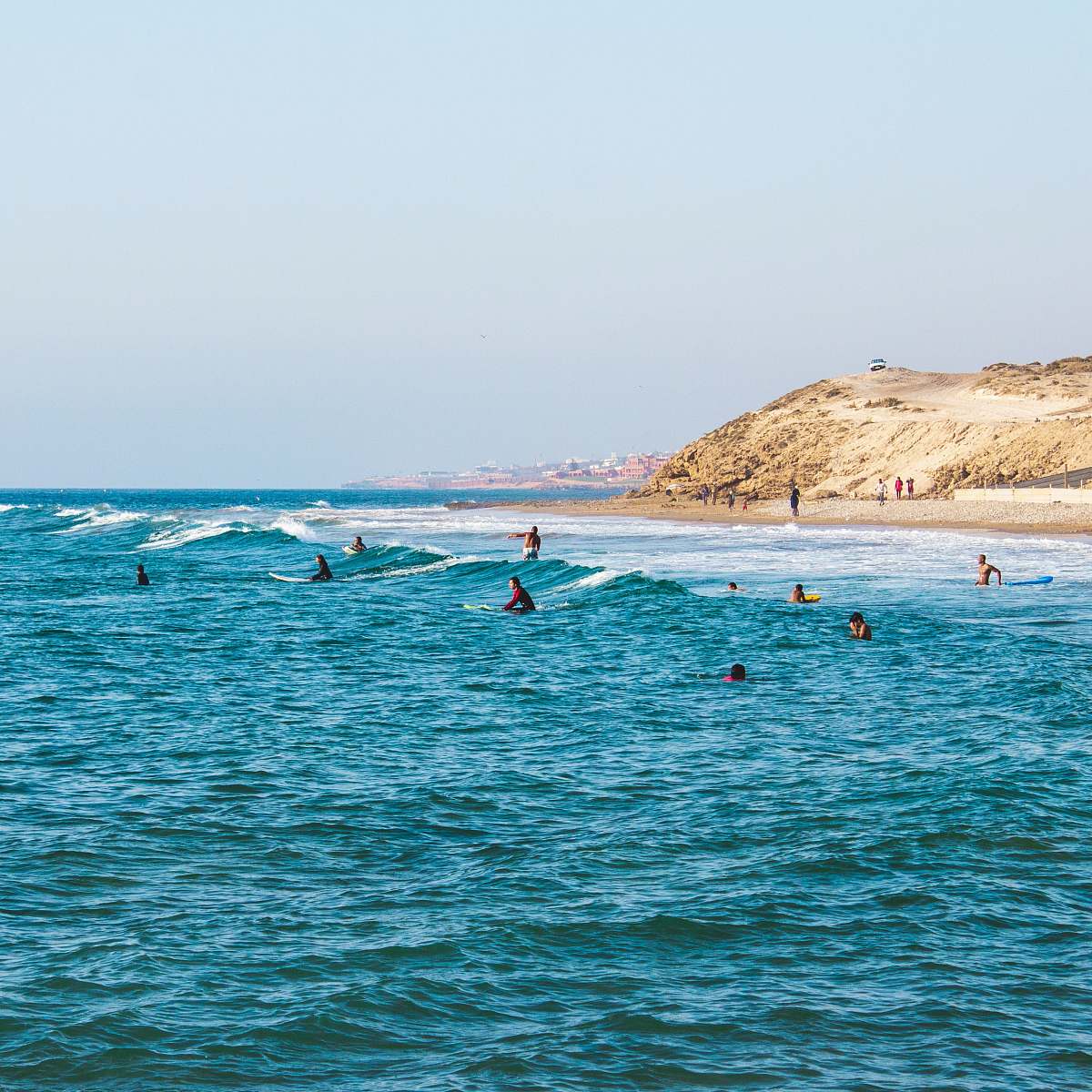 beach people riding surfboards in ocean at daytime water