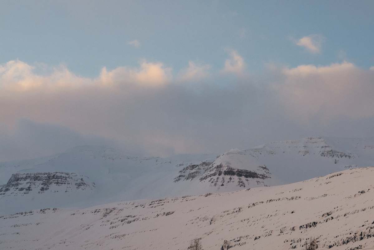 grey mountain covered with snow under white and blue sky during daytime mountain