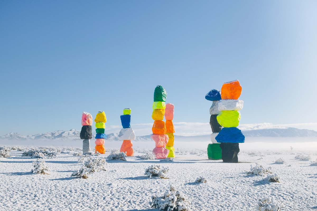 Discover a stunning scene featuring a group of vibrant, multi-colored rocks arranged as artistic sculptures on a pristine blanket of snow. This unique outdoor composition captures the beauty of nature's palette contrasted against the serene white snow, making it a perfect visual for winter art projects, landscape photography, or creative winter-themed designs.