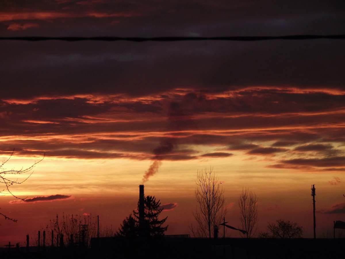 sky smoke going out on pipe during golden hour sunset