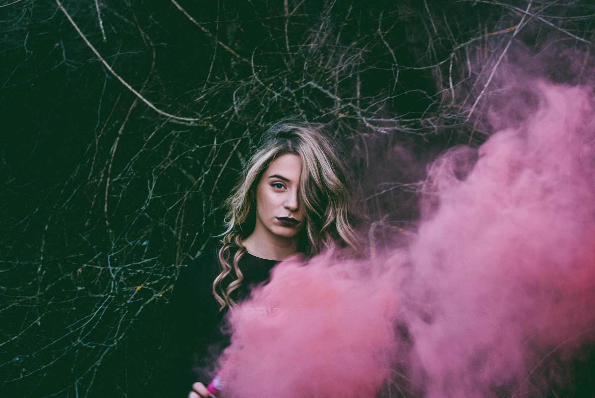 human woman standing near pink smoke person