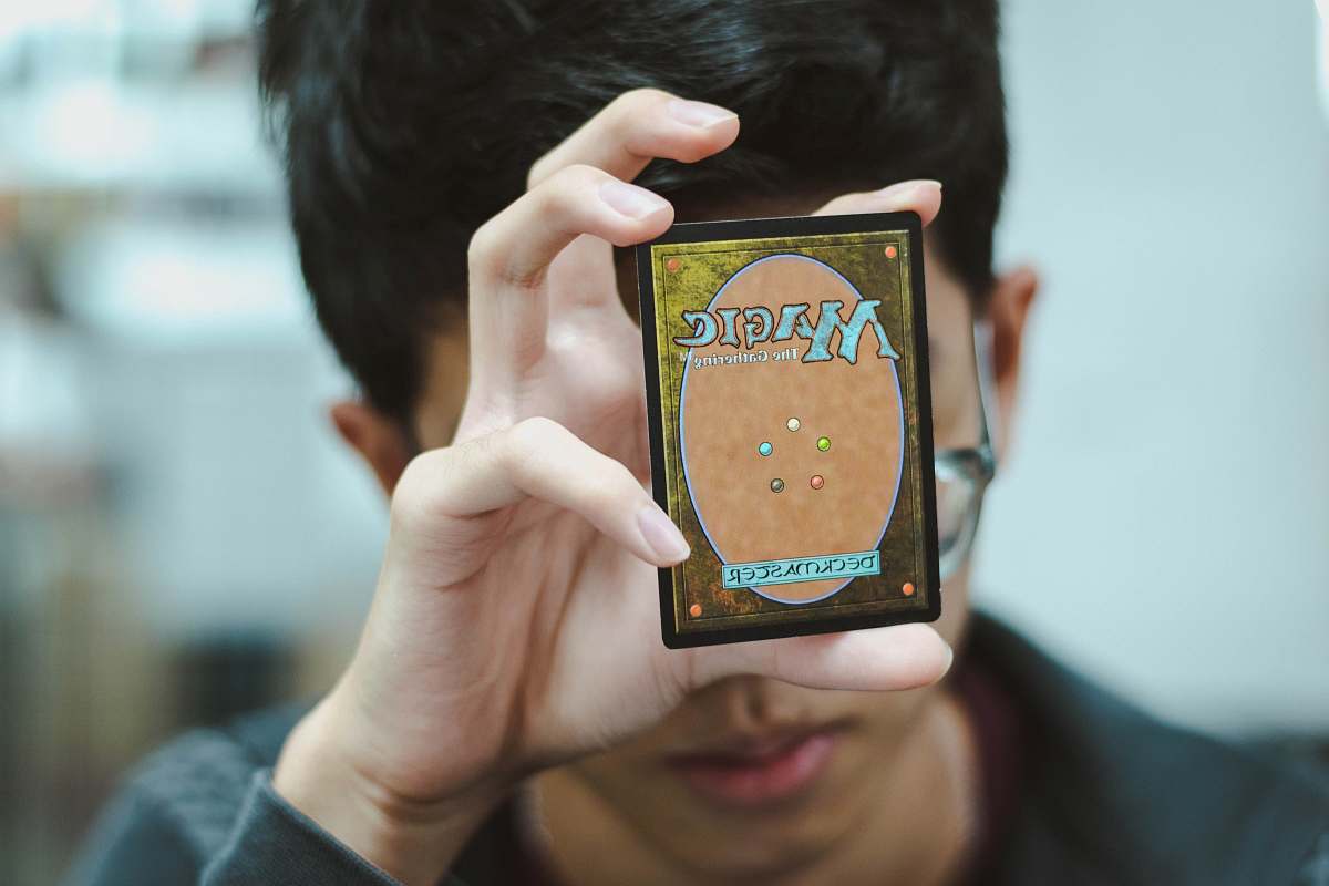 human boy holding Magic: The Gathering trading card people