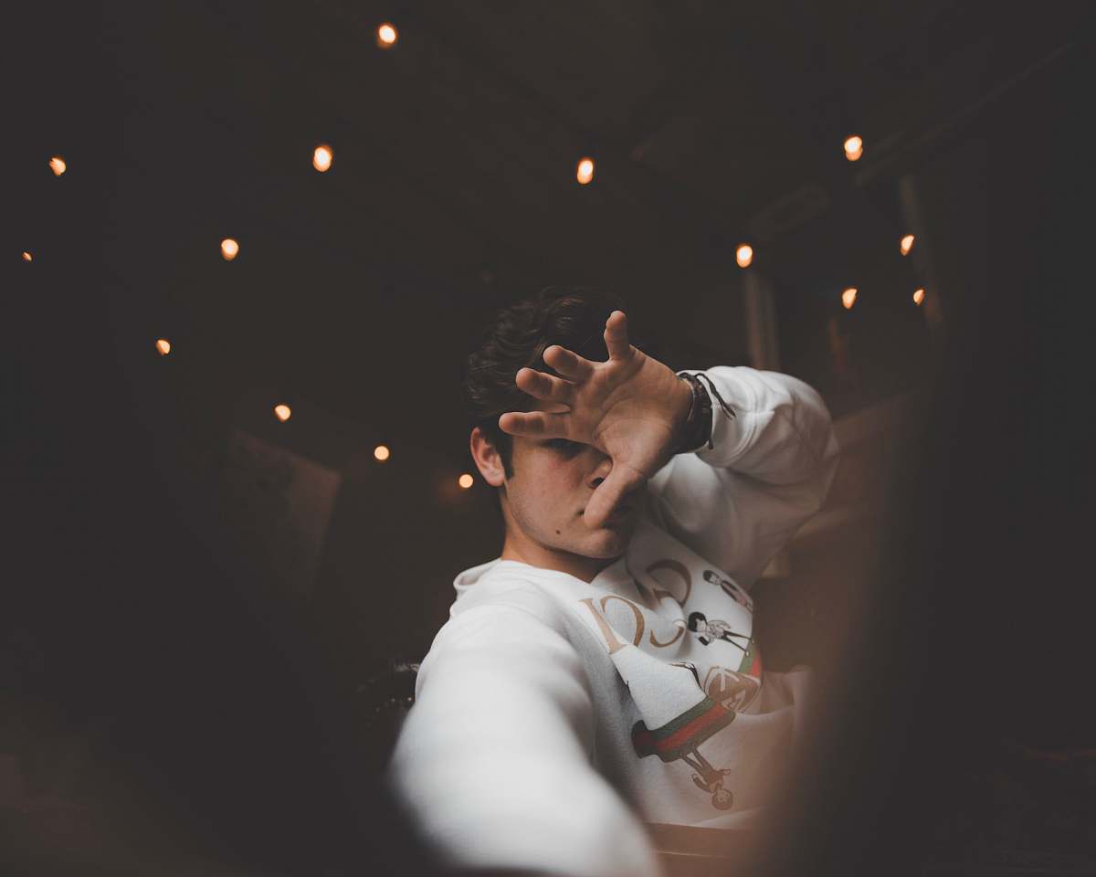 human man covering his face with one hand people