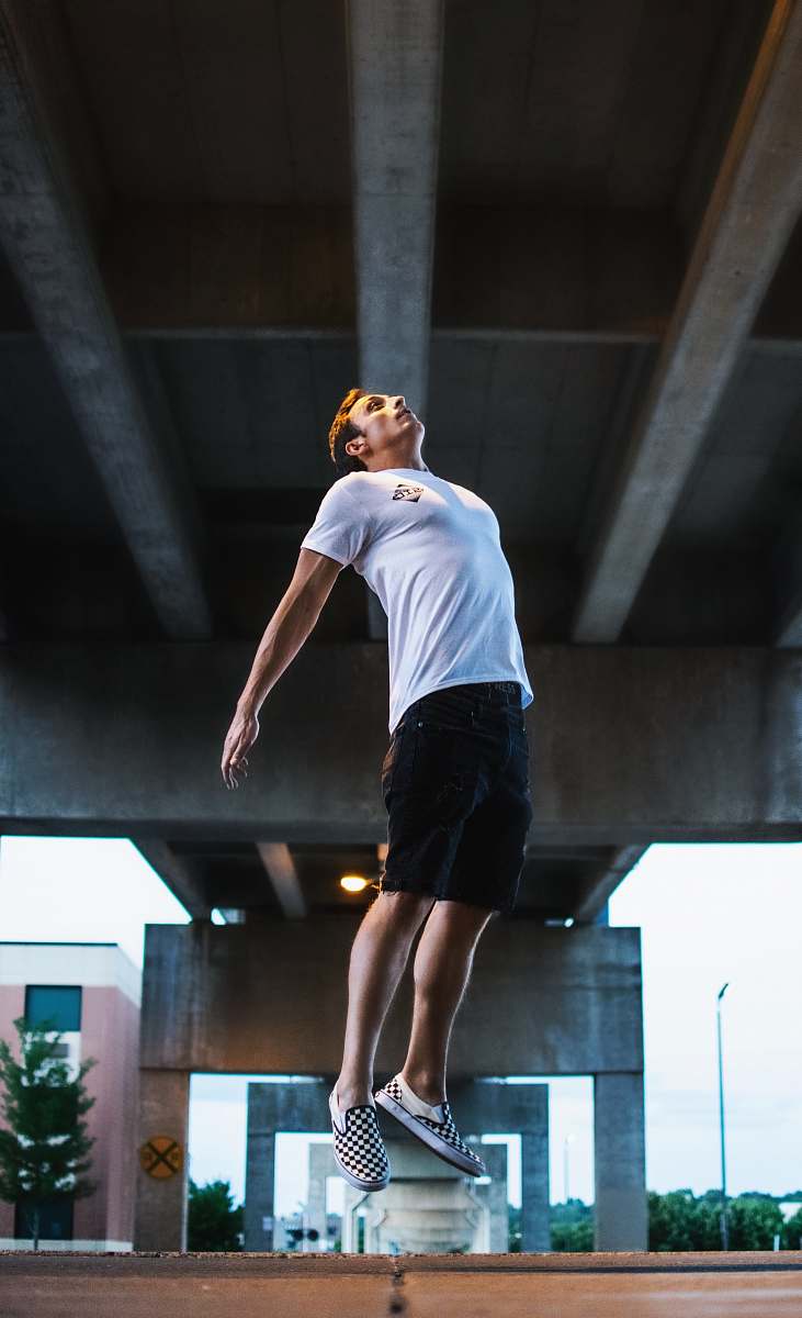 human man jumping on the middle of the road people