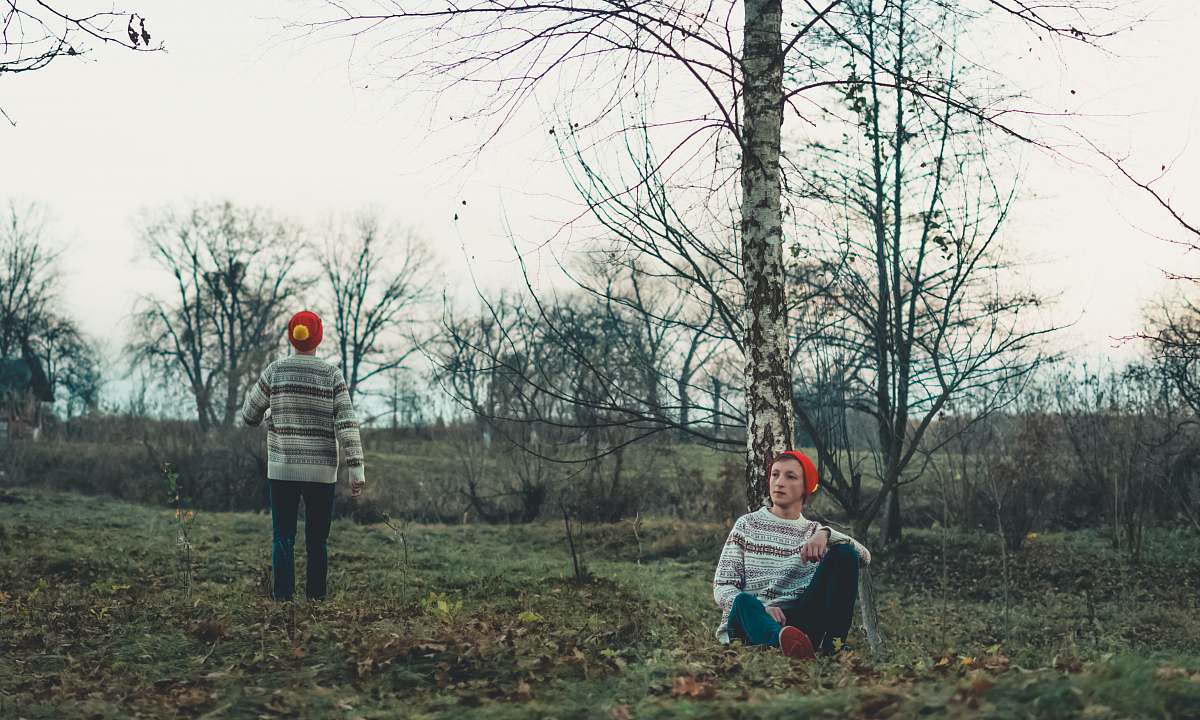 apparel man sitting beside tree clothing