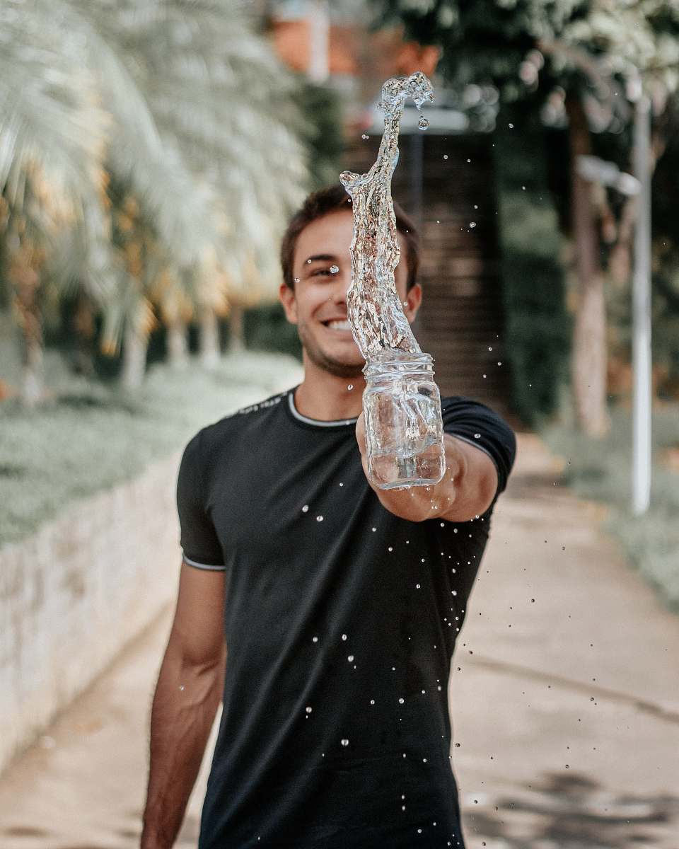 human selective focus photography of man throwing water nature