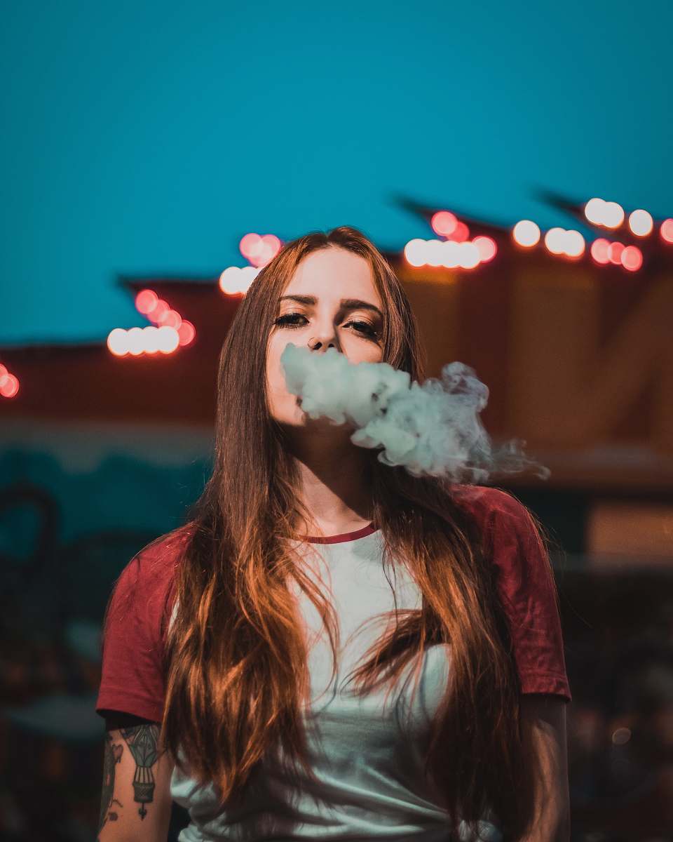 human woman in white and red raglan t-shirt smoking smoke