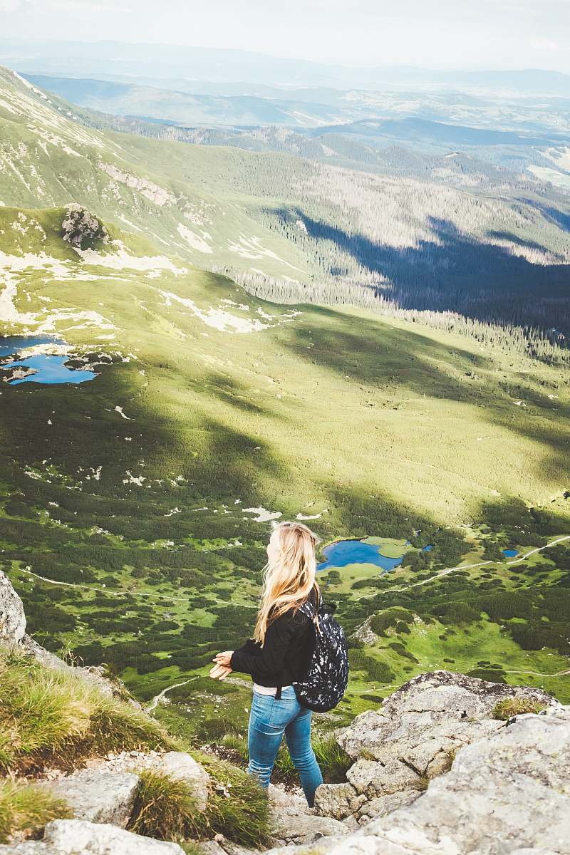 human woman standing on mountain during daytime outdoors