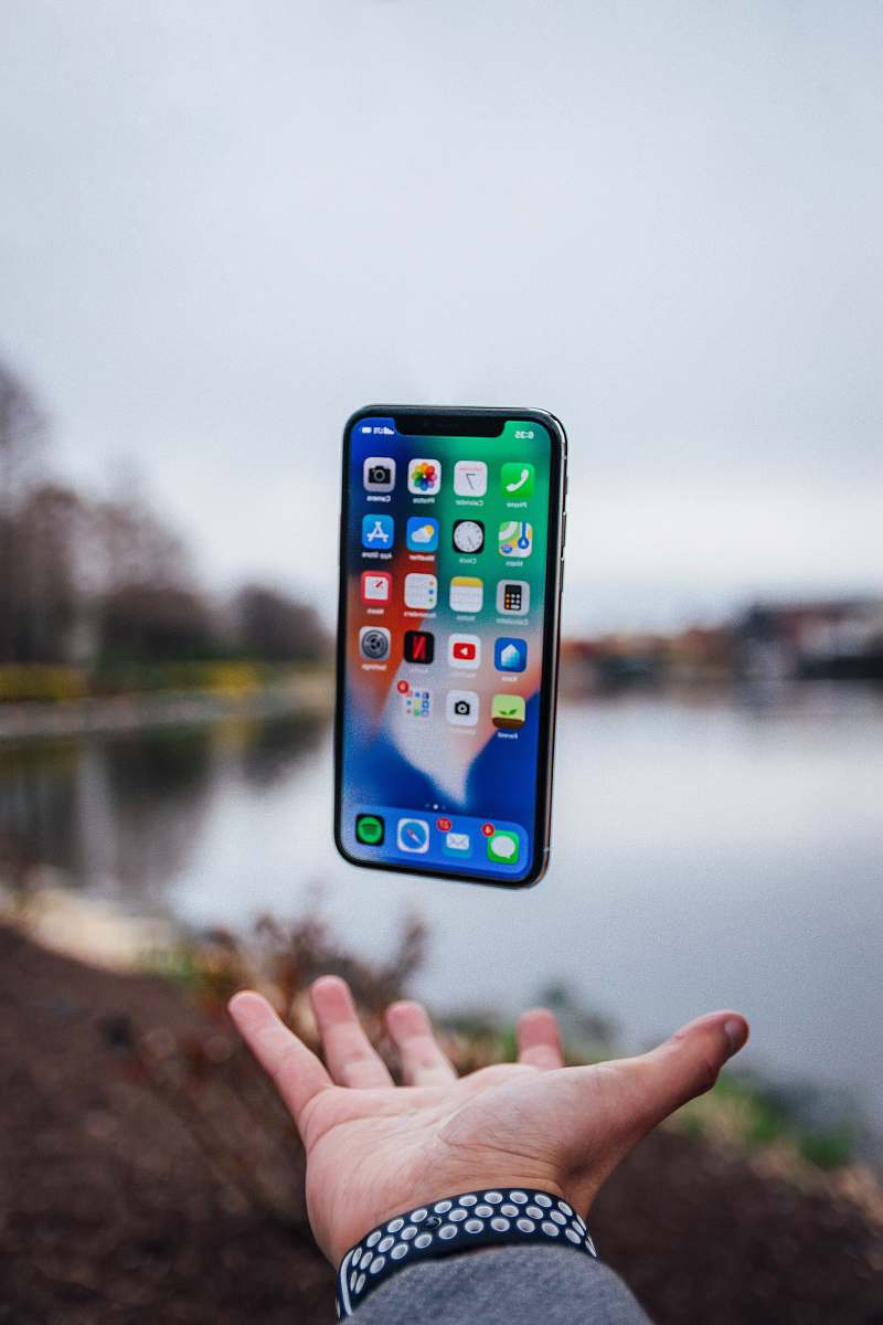 iphone silver iPhone X floating over open palm cell phone