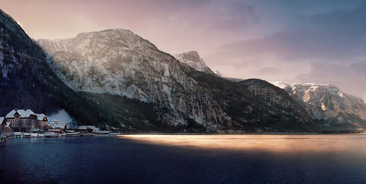 landscape brown and white house beside body of water covered with shadow of mountain mountain