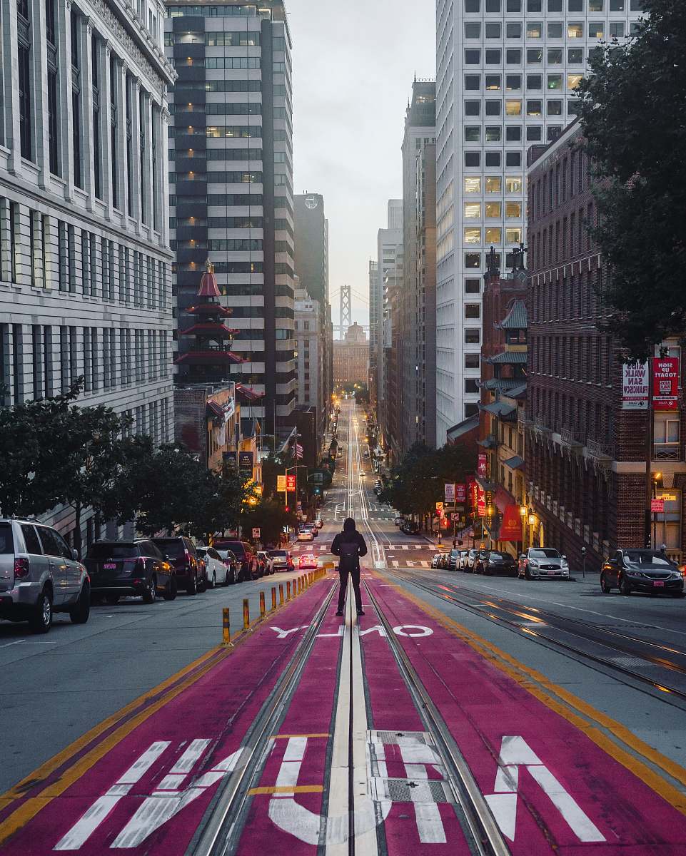 road person standing in middle of road in middle of city city