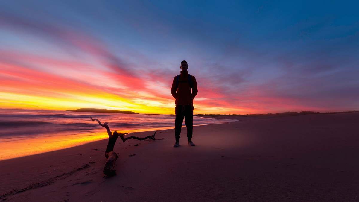 sydney man standing on a beach during sunset australia