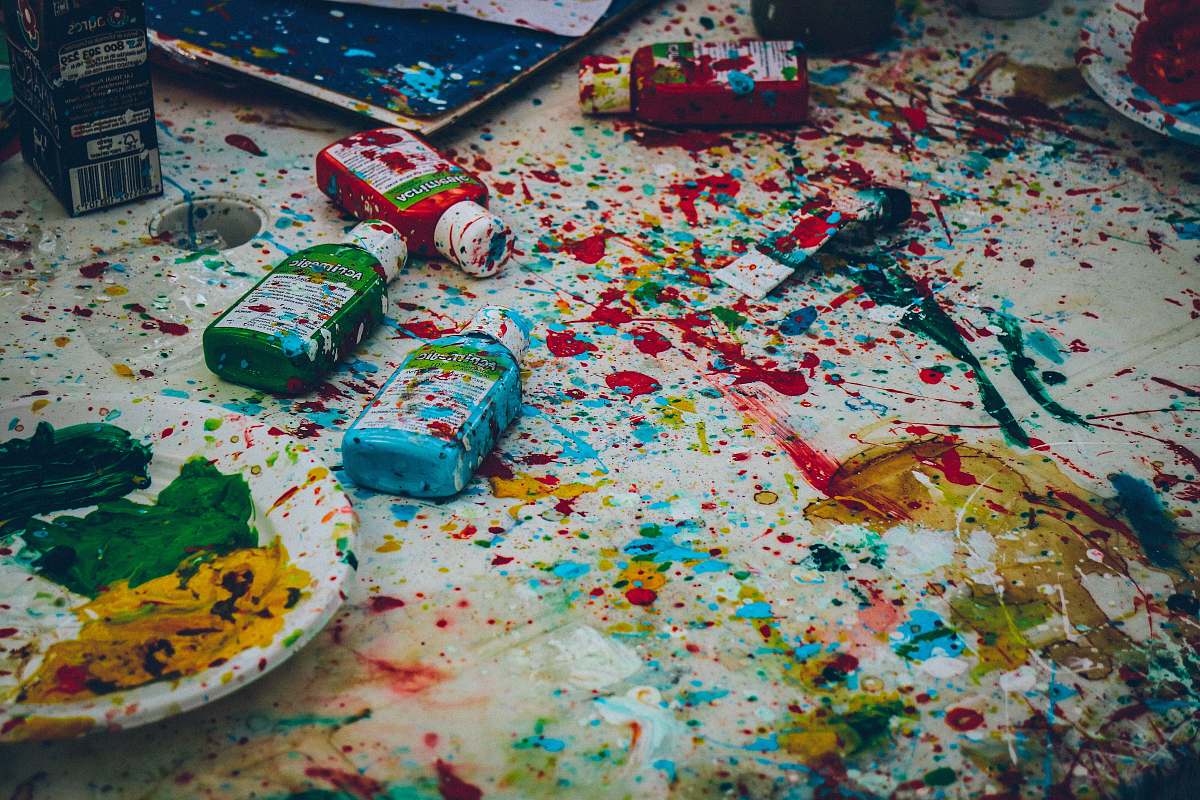 food assorted-color bottles on white surface with paint scribbles dessert