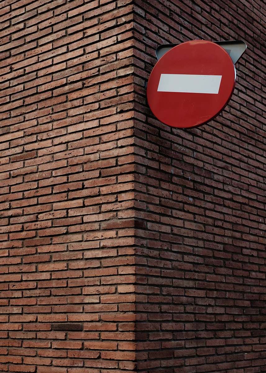 brick red and white signage on red brick wall at daytime wall