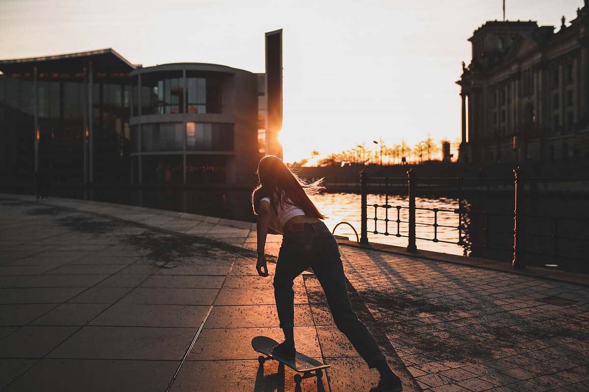 germany woman playing skateboard near river during daytime skateboard