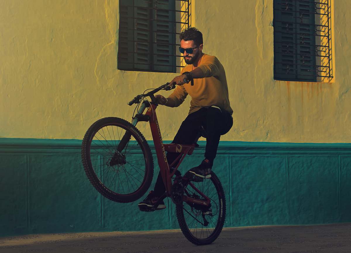 bike man riding bicycle doing tricks near building photography man