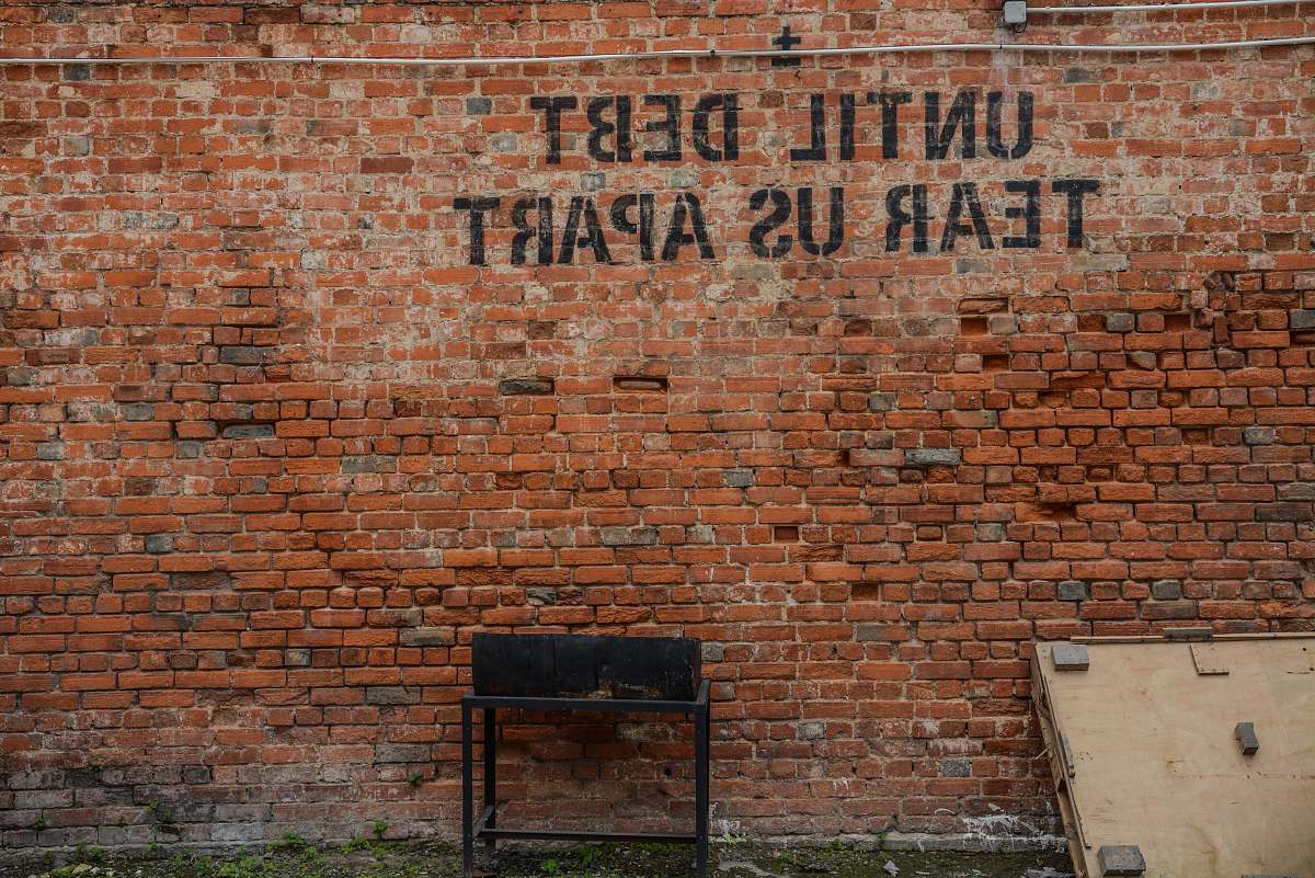 debt Until debt tear us apart printed red brick wall at daytime brick wall