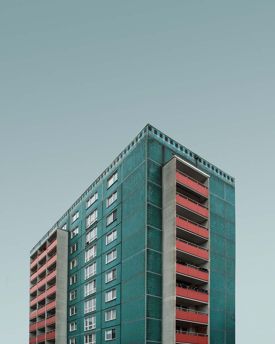 urban blue and white building under dark clouds city
