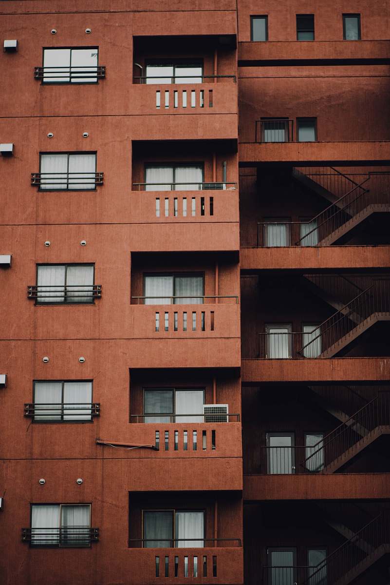 housing brown concrete building with stairs on the side window