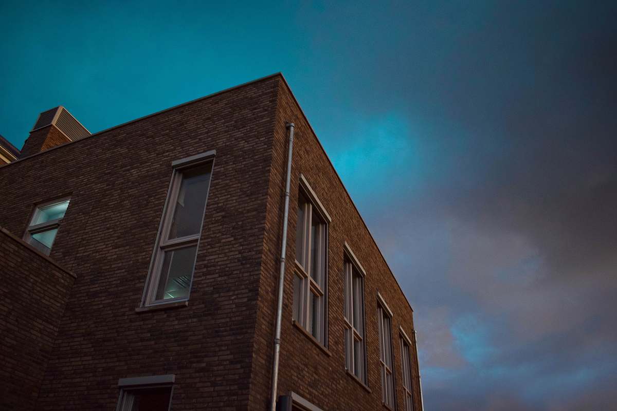 window low angle photography of a brown concrete building brick