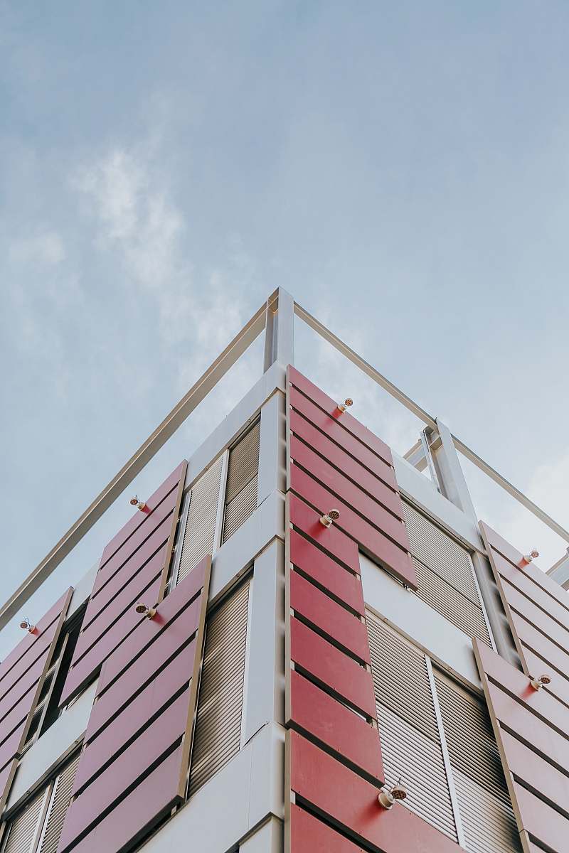 urban low-angle photography of red and beige concrete building at daytime city