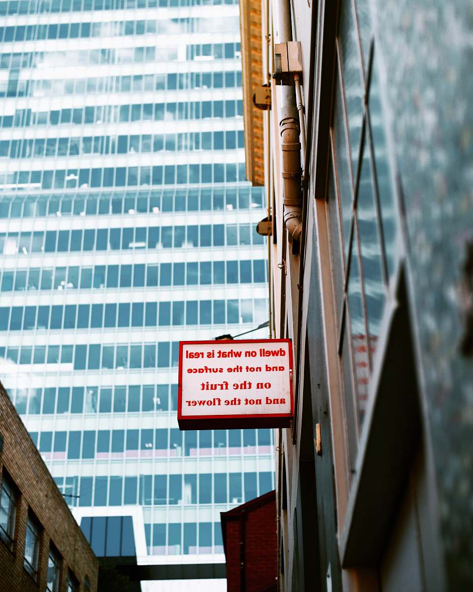urban wihte and red sign board near mirror wall building message