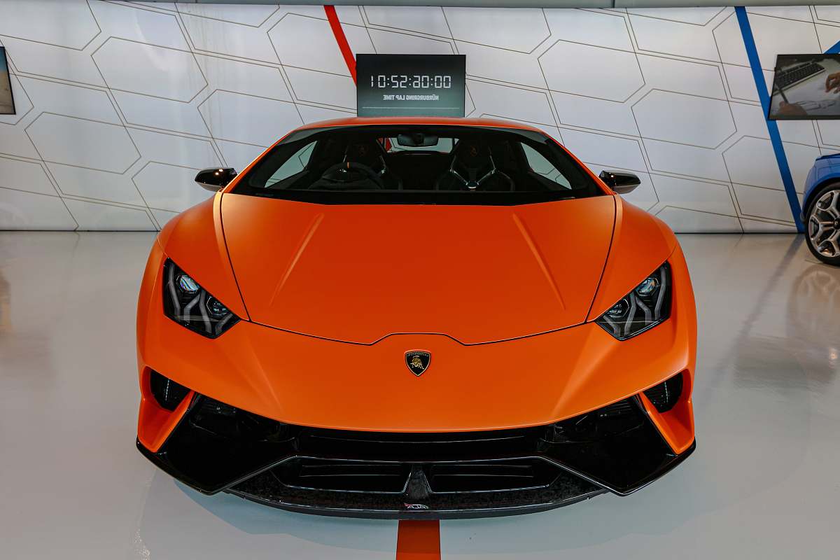 automobile orange car parked near cars sports car