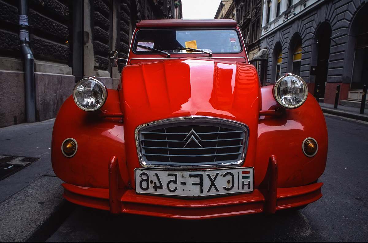 light red Citroen car parked on road headlight