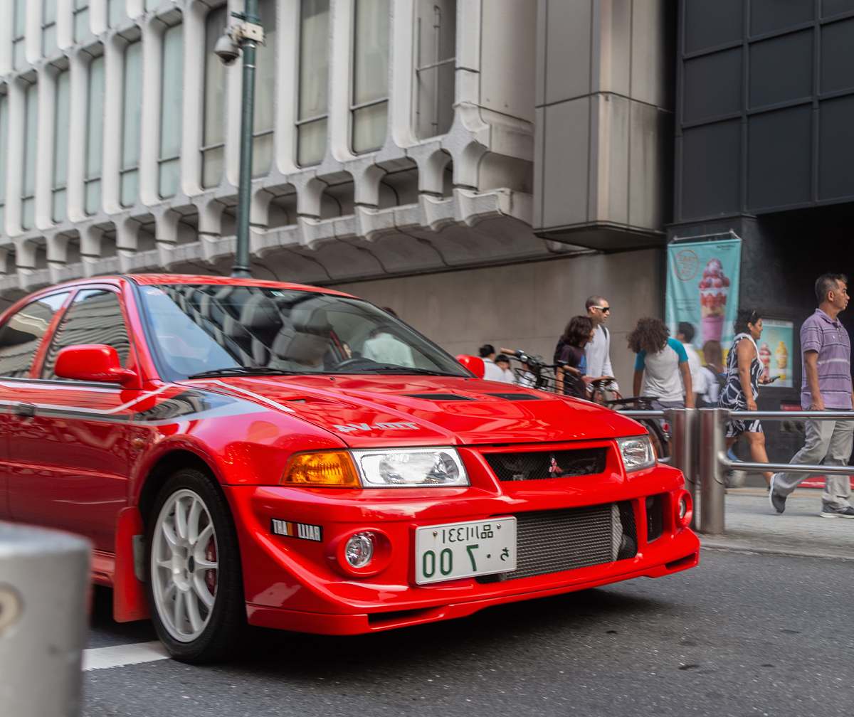 automobile red Mitsubishi vehicle on road transportation