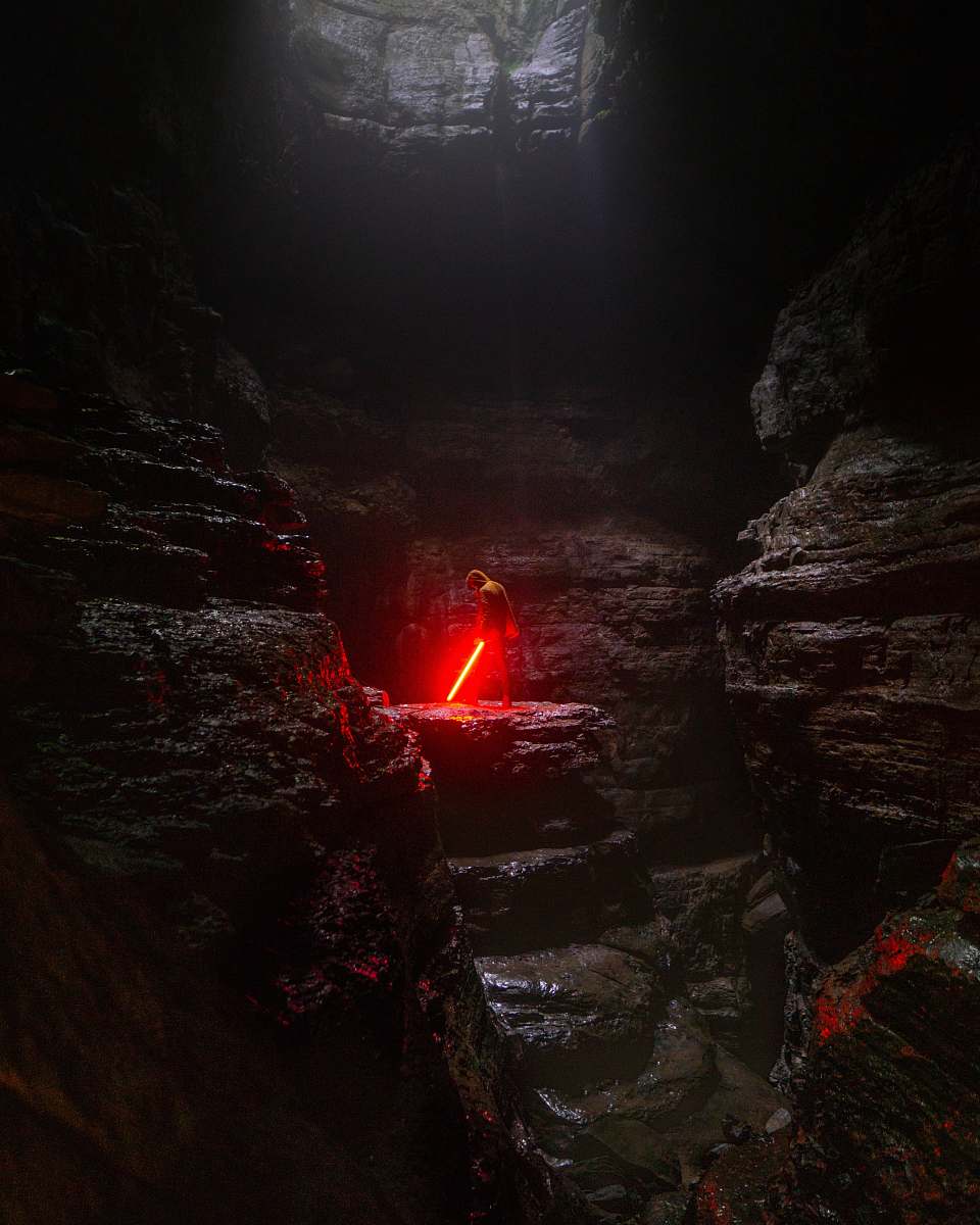 hole person holding red lightsaber nature