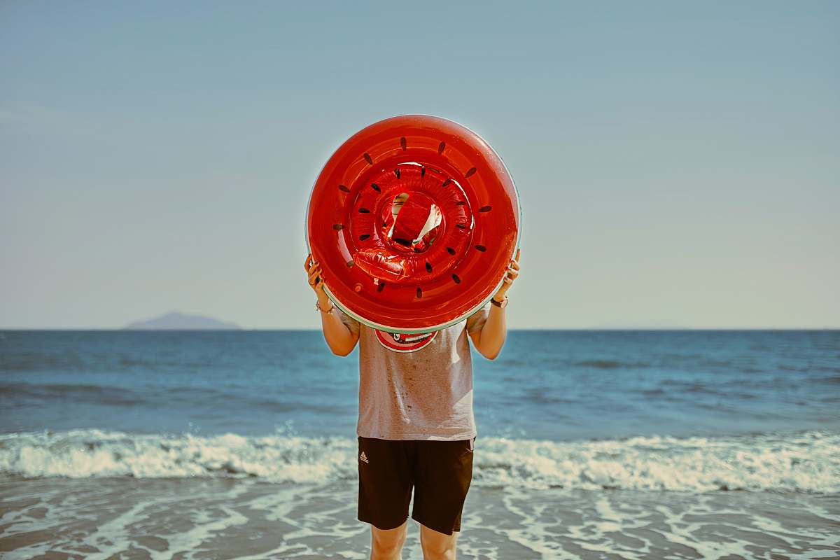 shorts person holding watermelon-themed inflatable ring apparel
