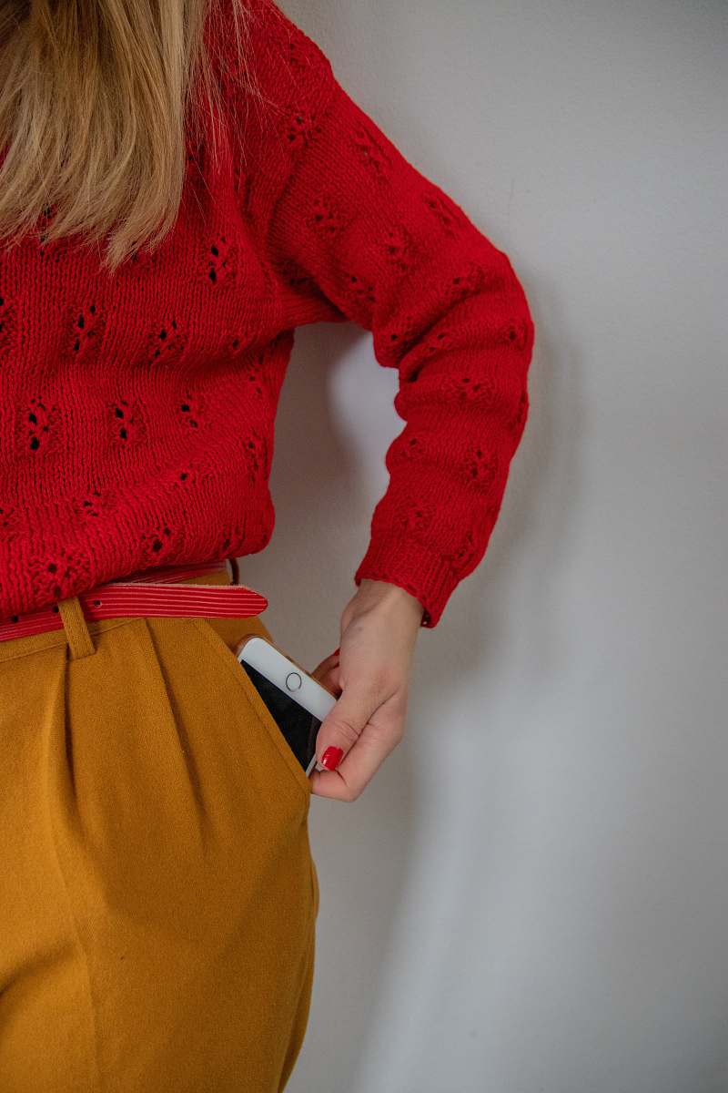 apparel woman standing while holding gold iPhone sweater