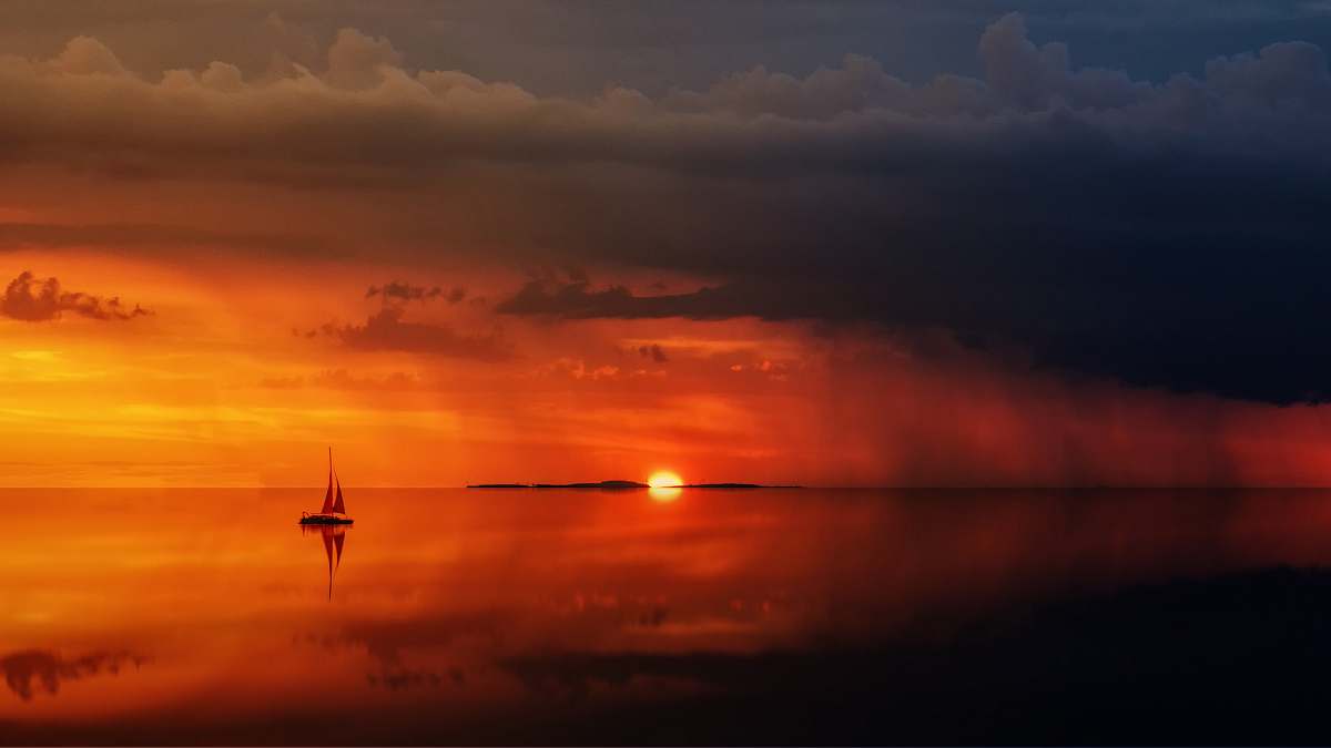 sky silhouette of sailboat on body of water sunrise