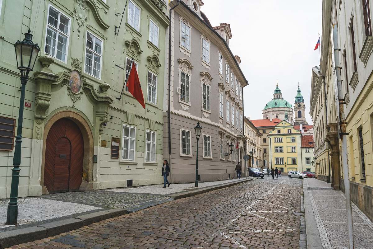 pavement woman walking on street with red flag above her sidewalk