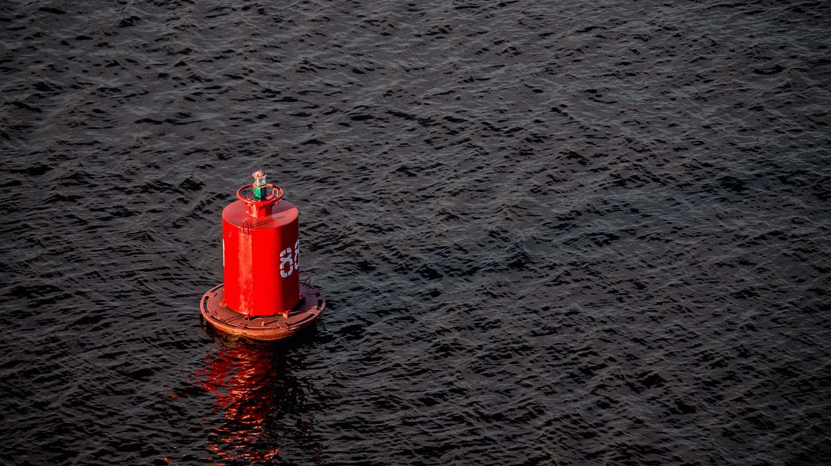 beacon red buoy on body of water sea