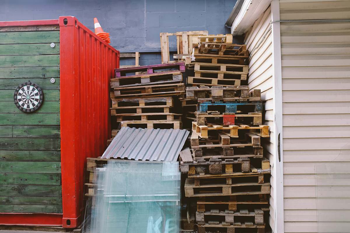 pallets brown wooden crate lot between red and green shipment container pallet