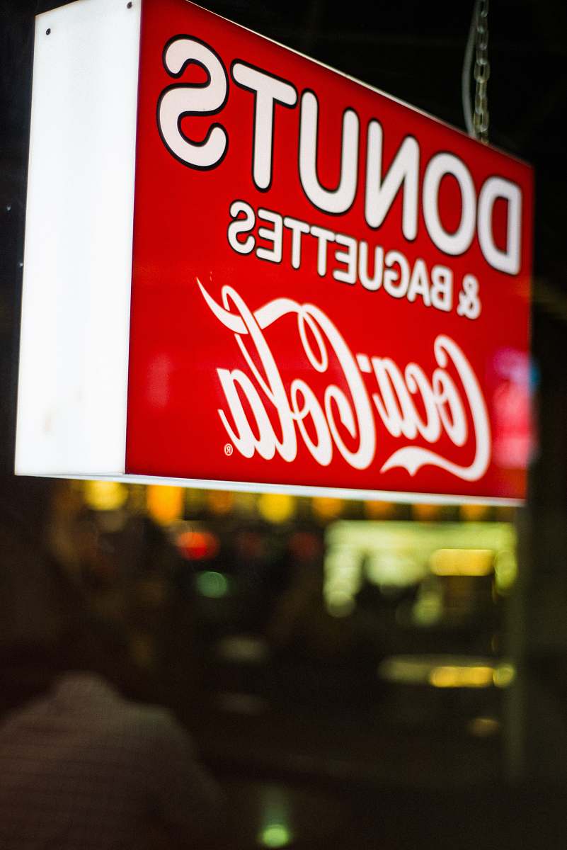 beverage close photography of Donuts & Baguettes Coca-Cola signage coke