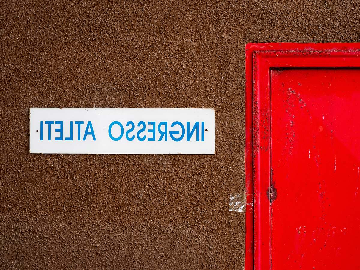 italy close-up photo of Ingresso Atleti signage beside door wall