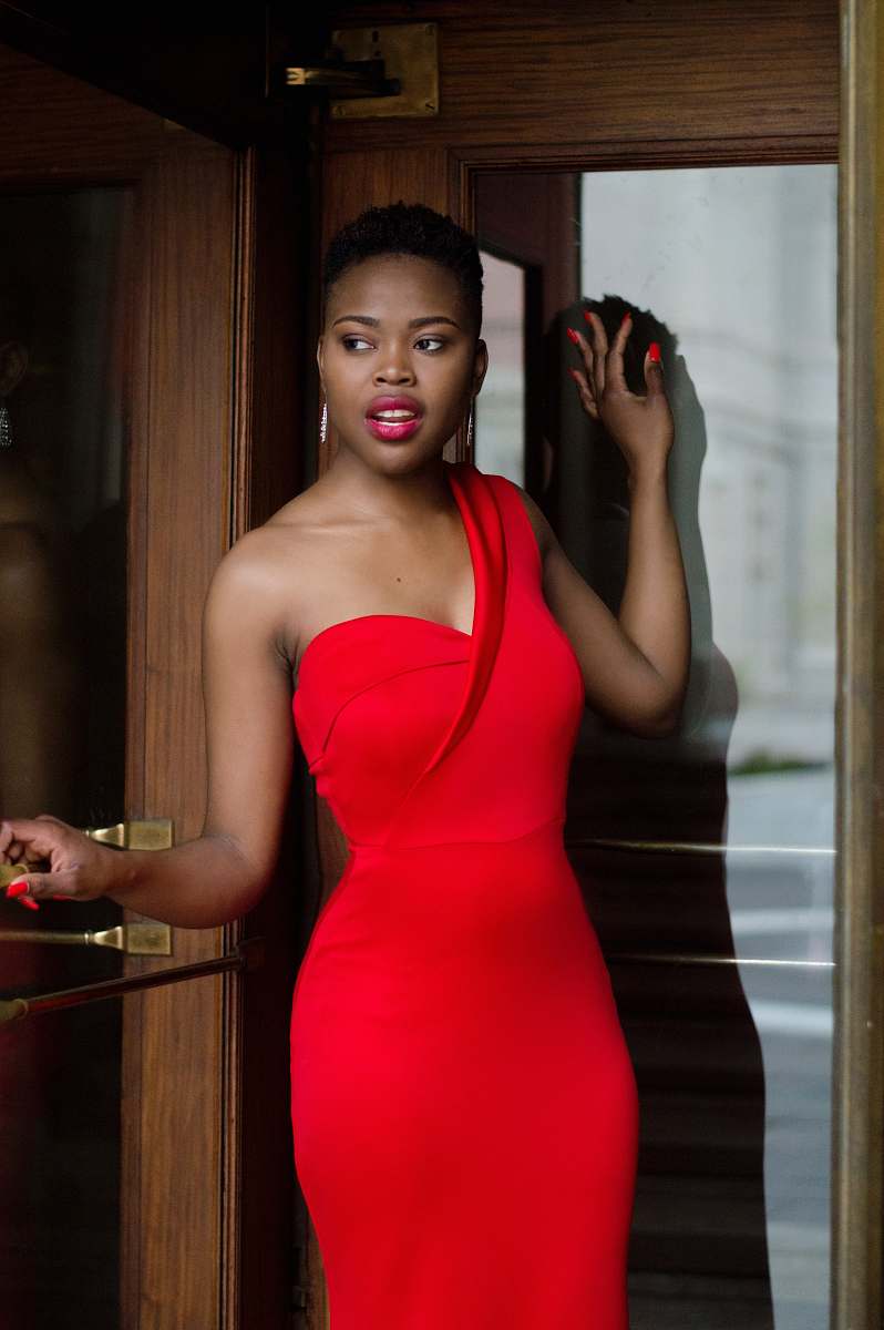 apparel woman wearing red bodycon dress holding glass door clothing