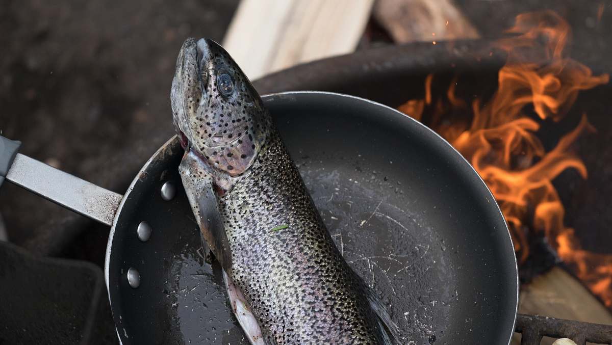 cooking fish on black frying pan fish