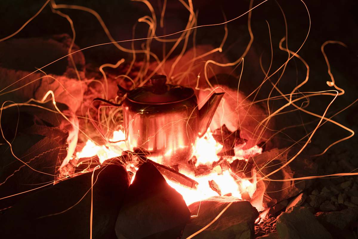 orange gray stainless steel kettle on fire pit light