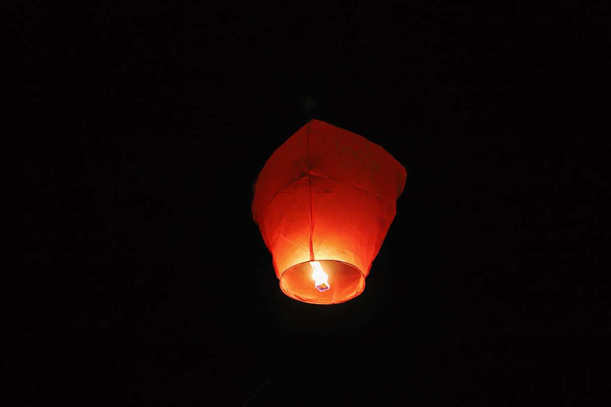 candle paper lantern with lighted candle in dark room lantern