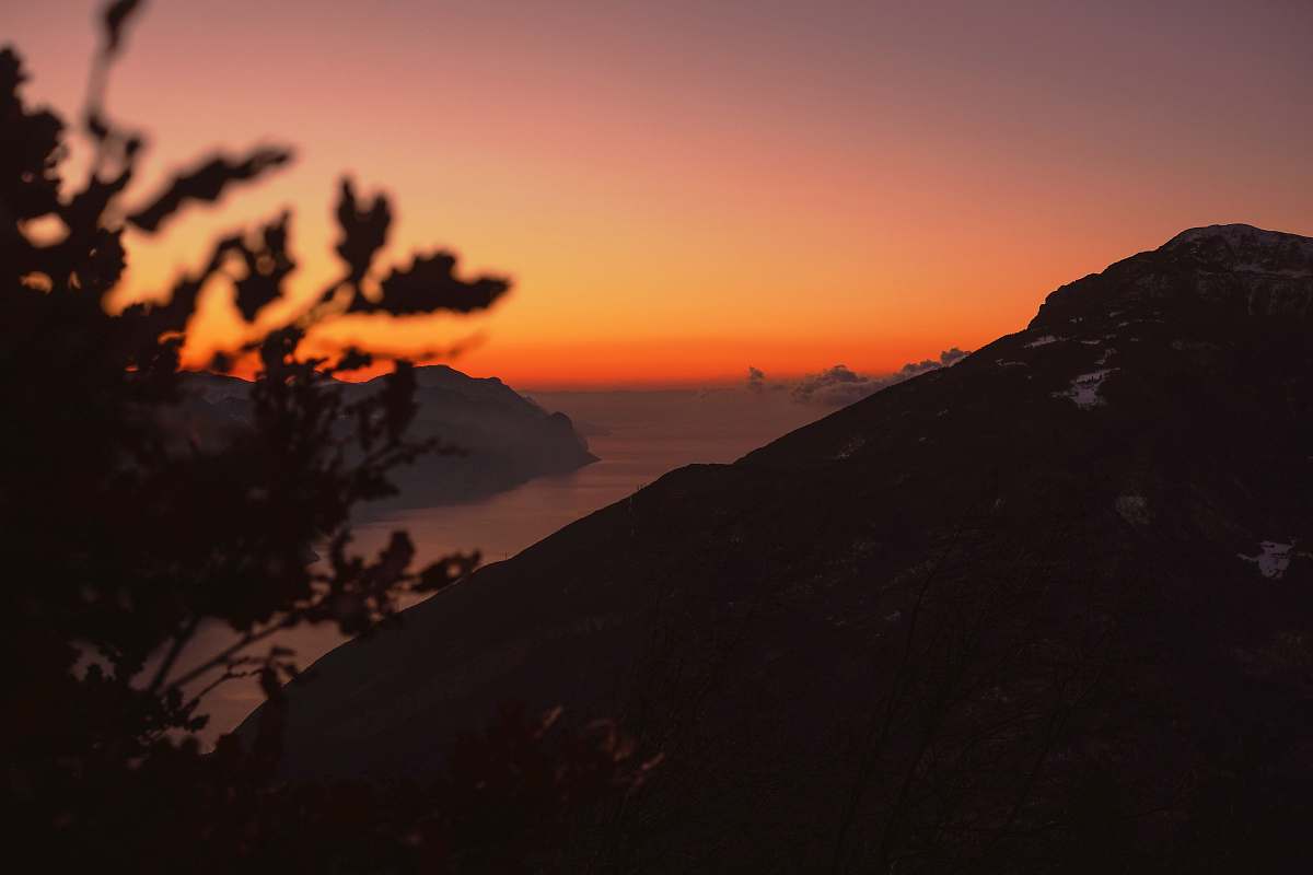 jar high-angle silhouette photography of mountain ranges with body of water in between during golden hour plant