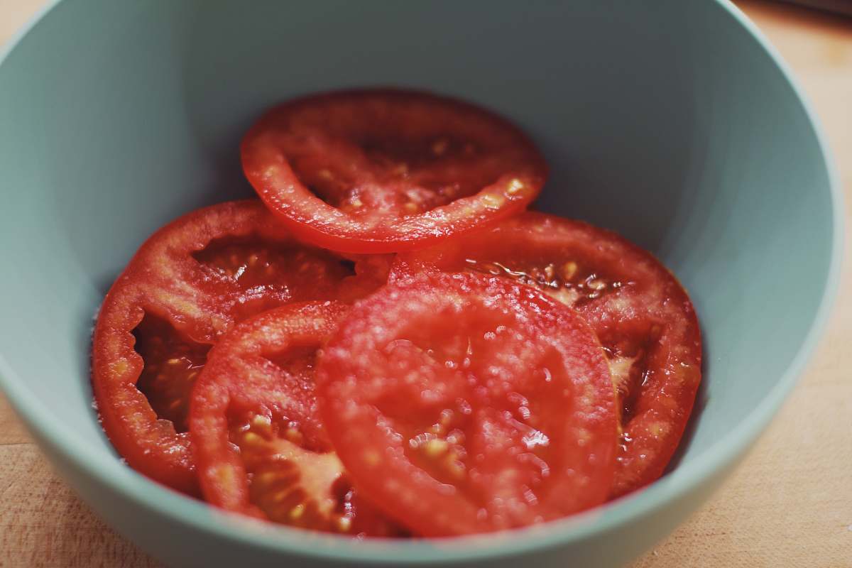 sliced sliced tomato in gray bowl ketchup