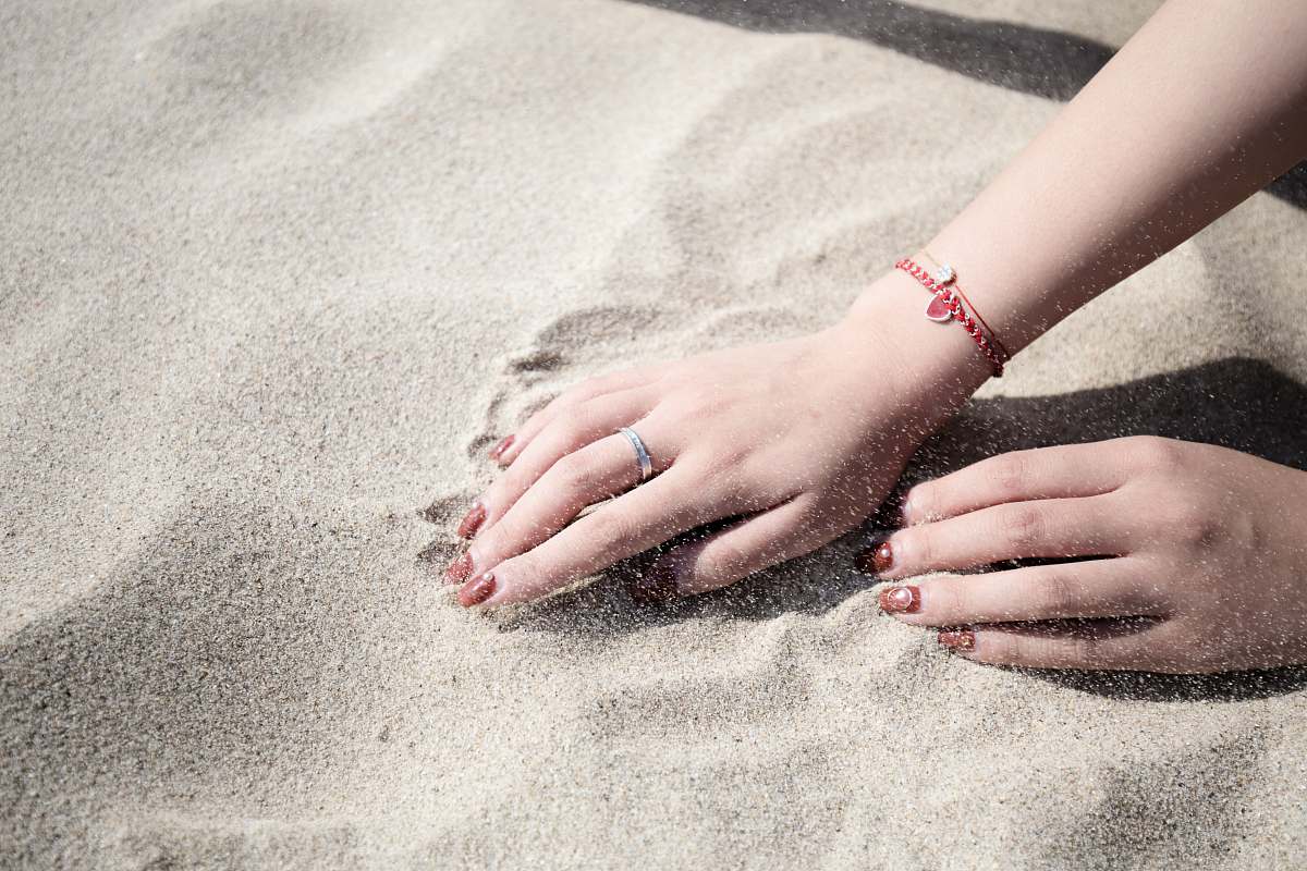 sand woman lying on white sand hands